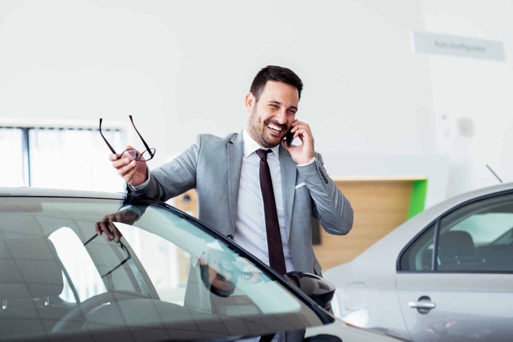 Man in Dealership on Phone scaled 1